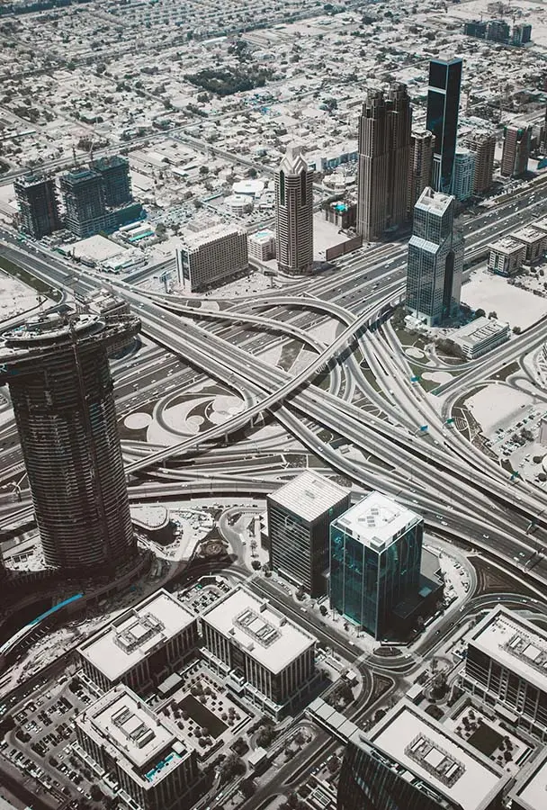 Picture of a city from above you see lots of streets and buildings a few skyscraprers, but no parks, trees