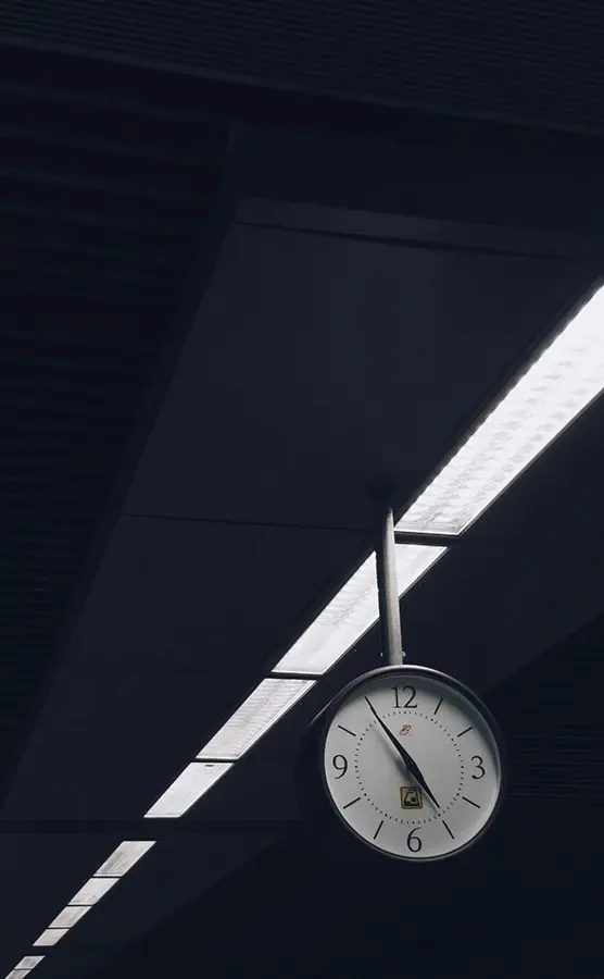 Picture of a clock. It looks like it hangs on a platform, at a train or subway station